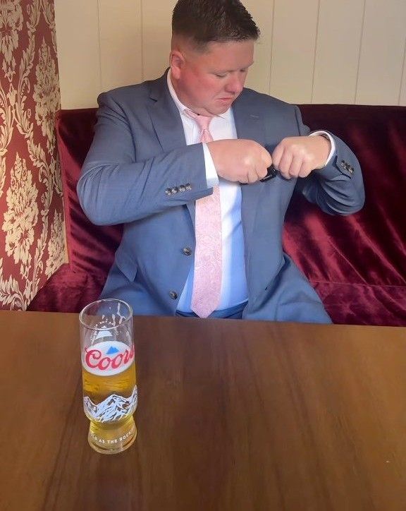 Big Dave in a suit, sitting in a red velvet booth at The Síbín with a pint