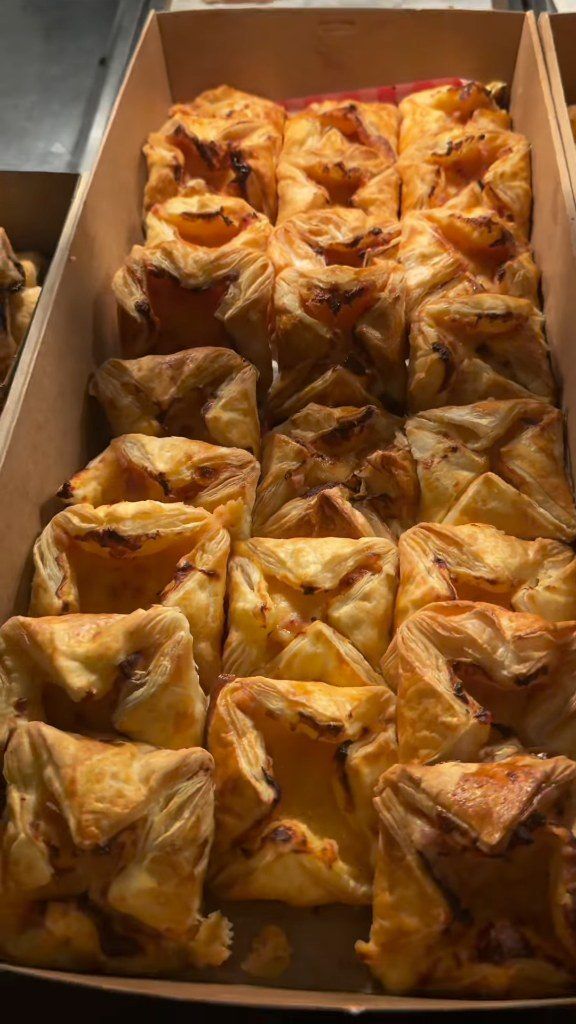 A catering box full of golden pastries