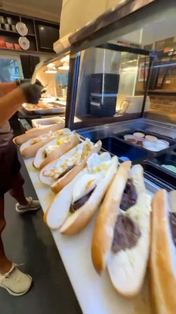 Breakfast rolls being filled with sausages and black pudding